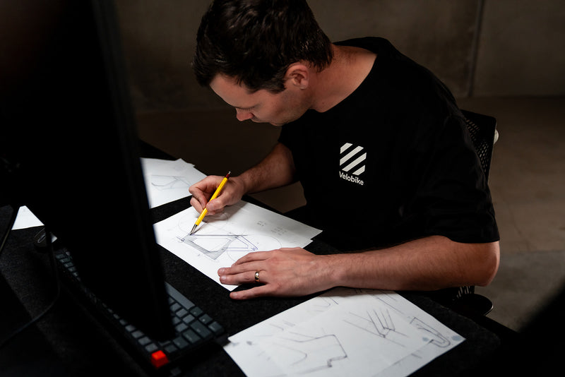 Person working on a design project with sketches and a laptop.